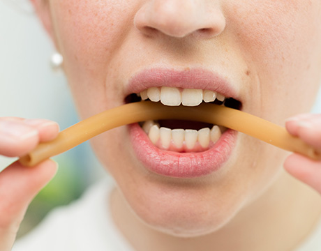 Frau erklärt kleinem Jungen wie man durch einen Strohhalm pustet