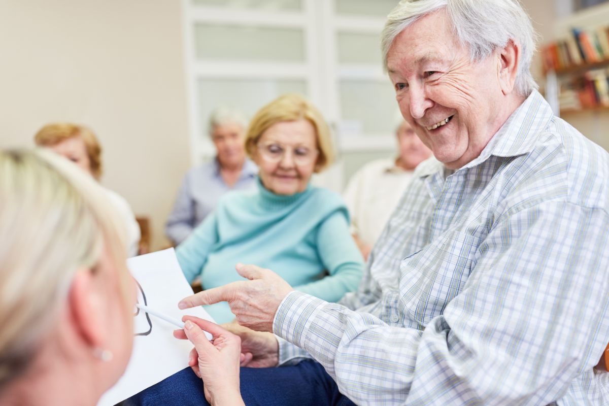 Logopädin erklärt Unterstützende Kommunikation einer älteren Dame.