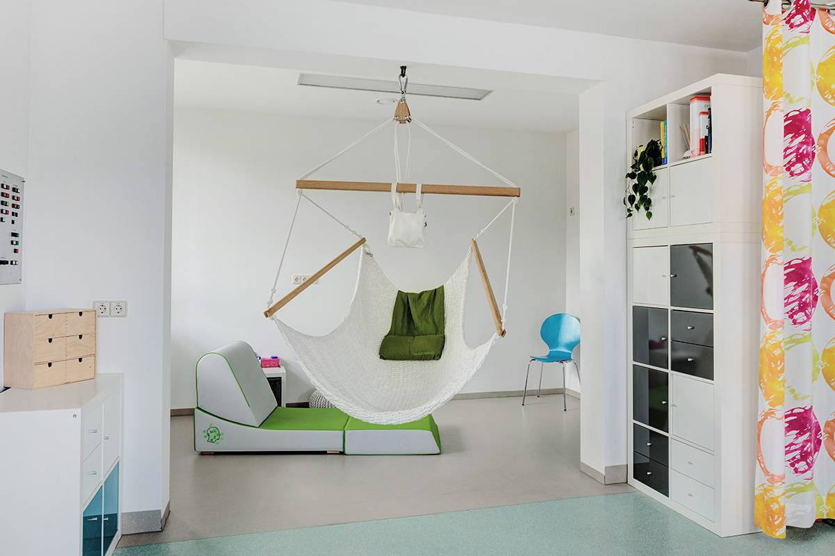 Raum mit weißem Hängetuch und blauem Stuhl.